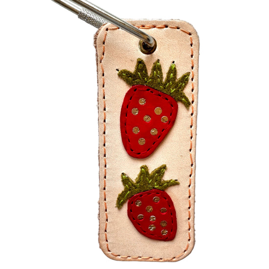 Keychain with strawberry designs on a beige background